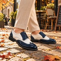 Paio di stringate uomo blu e bianche con punta brogue lucida in movimento