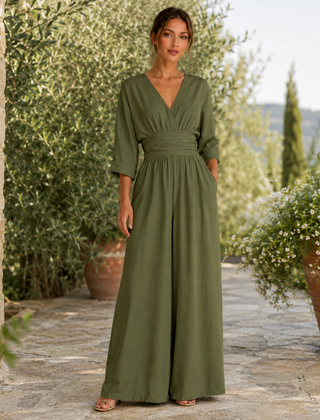 Tuta verde scuro con maniche tre quarti e gamba larga in giardino mediterraneo