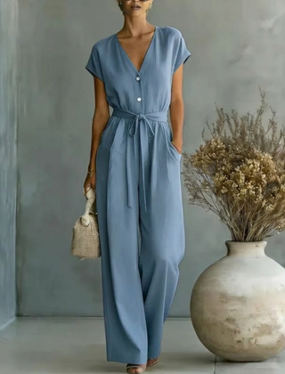 Tuta donna lunga blu con scollo a V, bottoni chiari e pantalone a gamba larga