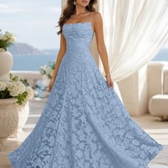 Vestito lungo azzurro con motivo floreale in rilievo e ampia gonna svasata sul mare