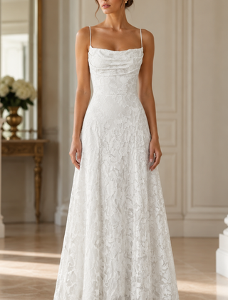 Vestito lungo bianco con corpetto drappeggiato e decoro floreale traforato in sala luminosa