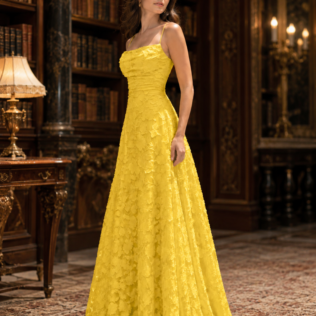 Abito lungo giallo svasato con corpetto drappeggiato, ripreso di tre quarti in interno elegante
