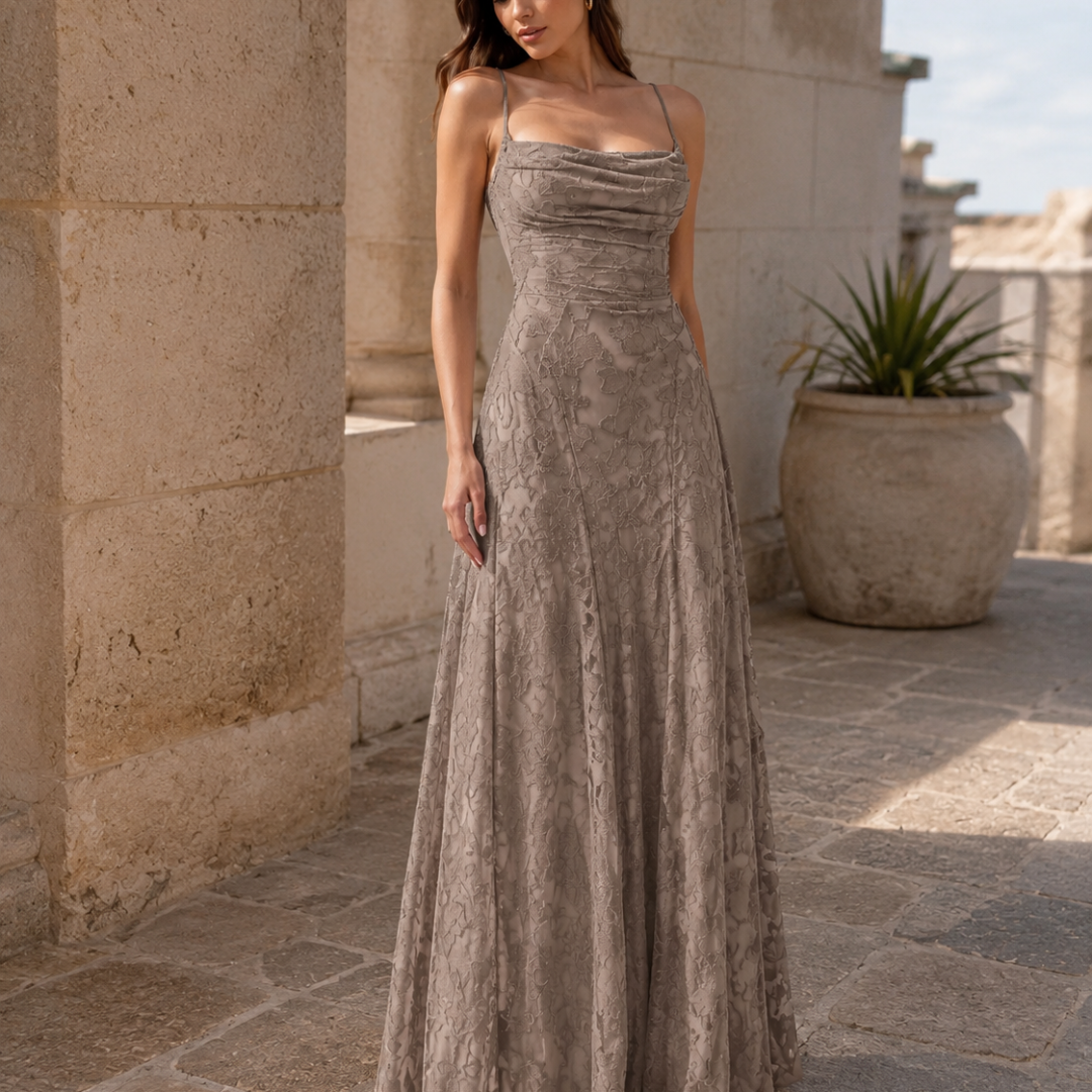 Vestito lungo grigio tortora con scollo drappeggiato e lavorazione floreale, cortile in pietra