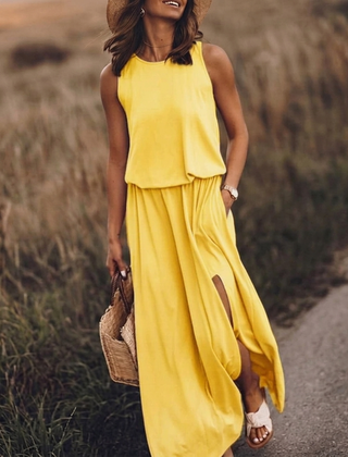 Vestito lungo giallo con girocollo e spacco laterale, indossato con cappello