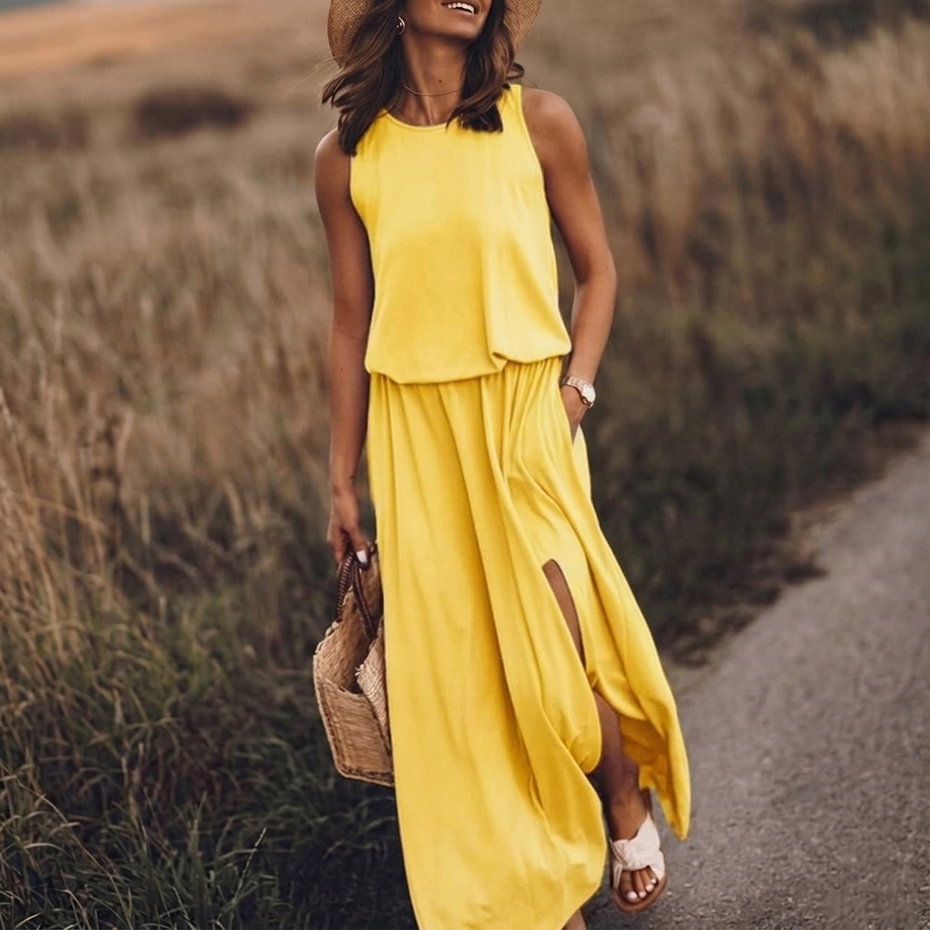Vestito lungo giallo con girocollo e spacco laterale, indossato con cappello